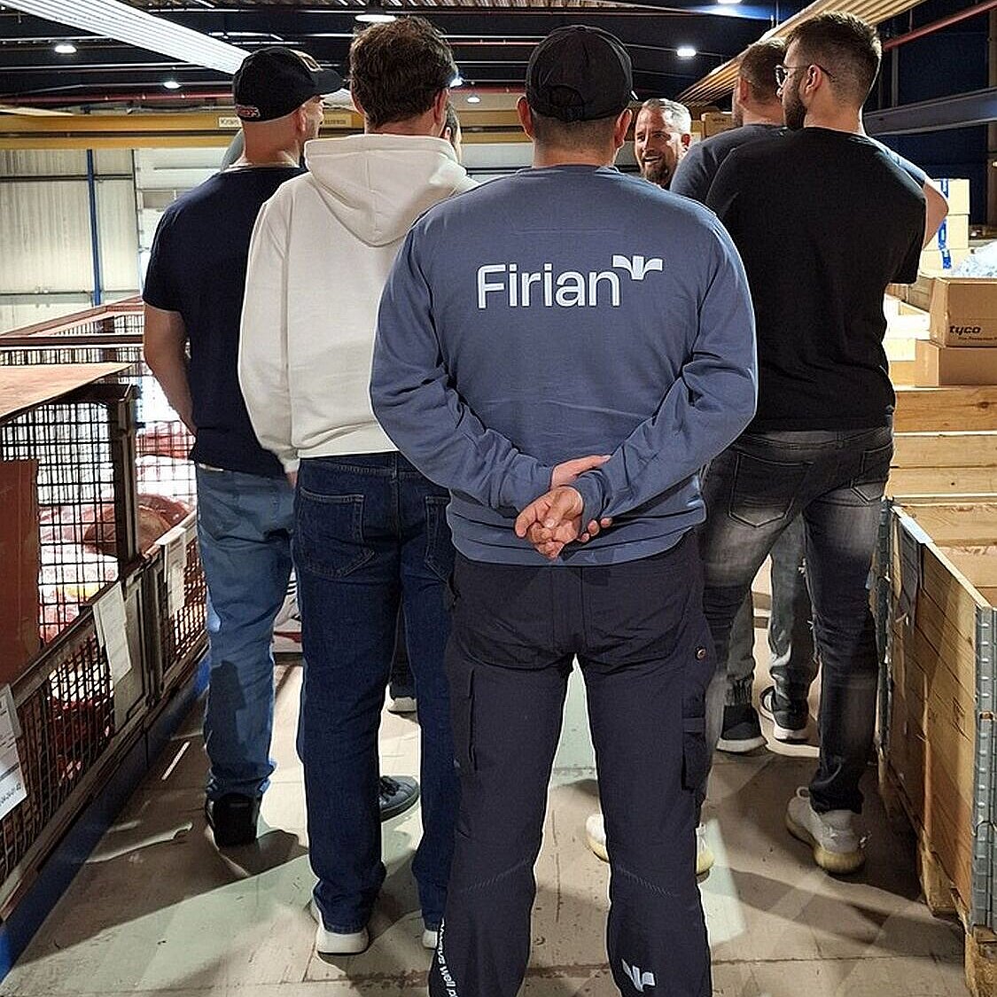 Männer stehen in Lager und werden herumgeführt